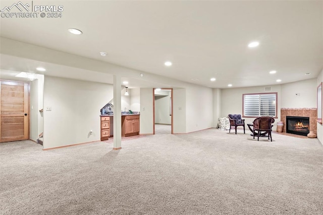 basement featuring a fireplace and light carpet