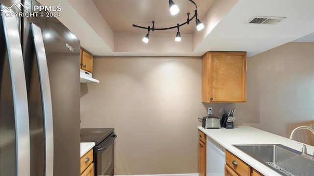 kitchen with stainless steel fridge, white dishwasher, a tray ceiling, sink, and black range with electric stovetop