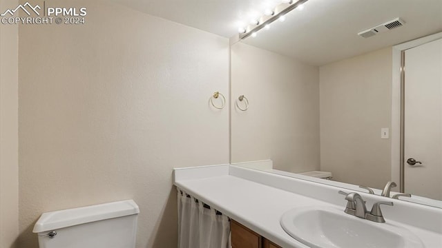 bathroom featuring vanity and toilet