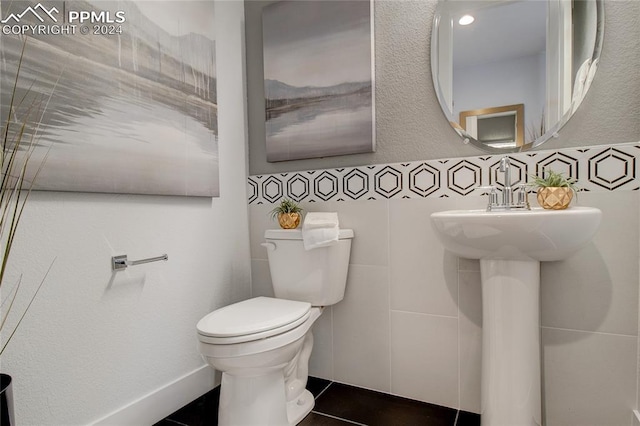 bathroom with tile patterned floors, sink, tile walls, and toilet