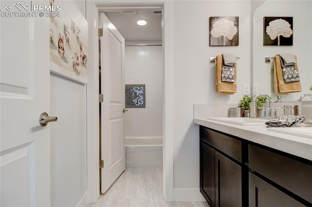 bathroom featuring vanity and tiled shower / bath combo