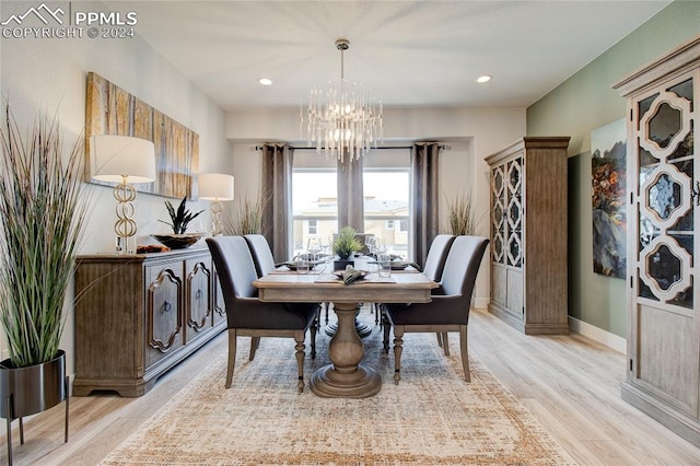 dining room with light wood-type flooring and an inviting chandelier