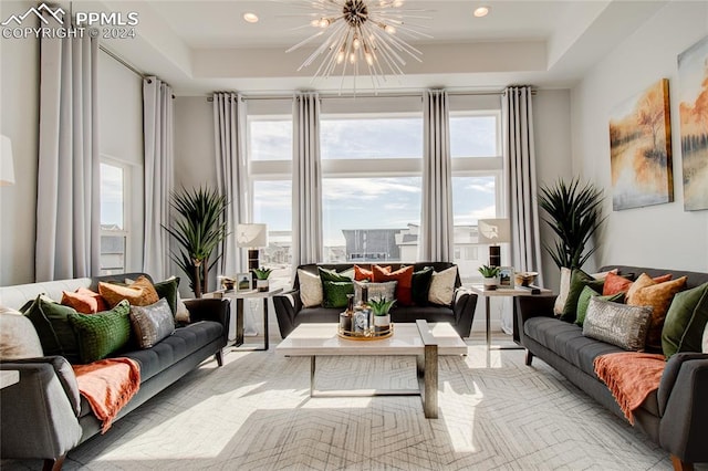 living room with a raised ceiling and an inviting chandelier