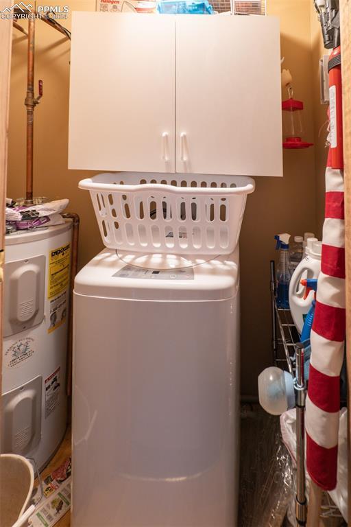 washroom featuring cabinets, washer / clothes dryer, and water heater