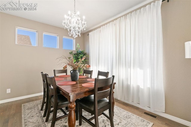 dining room with hardwood / wood-style floors and a notable chandelier