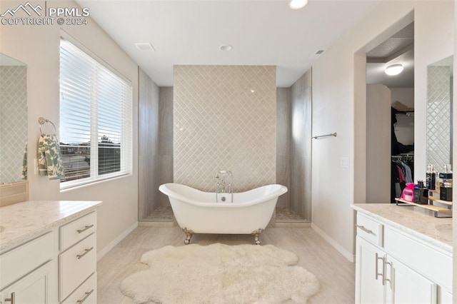 bathroom featuring a washtub, tile walls, and vanity