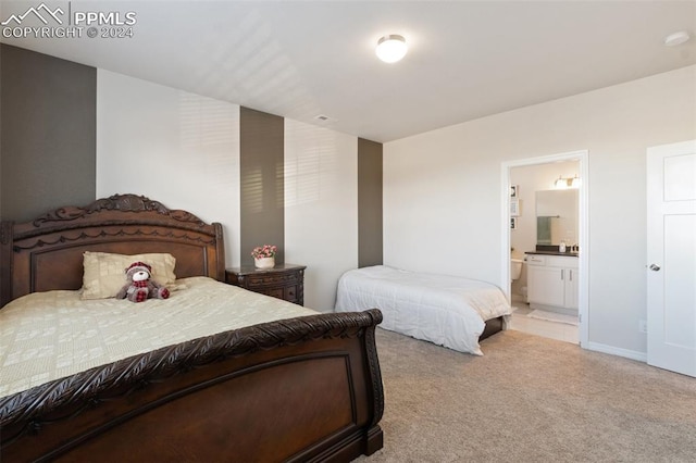 bedroom with light colored carpet and ensuite bath