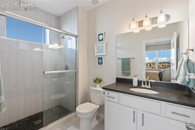 bathroom featuring plenty of natural light, vanity, an enclosed shower, and toilet