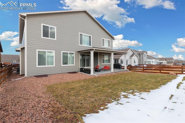 snow covered property with outdoor lounge area, a patio, and a lawn