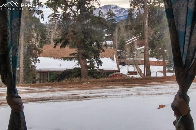 yard covered in snow with a mountain view