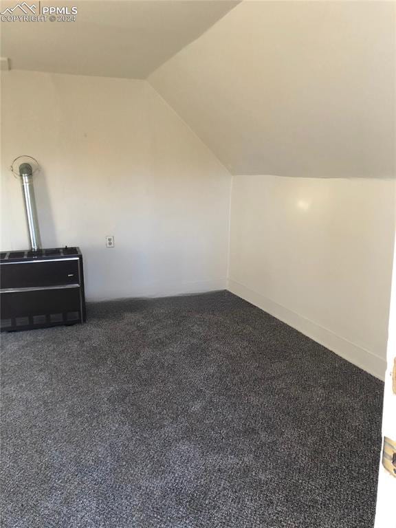 bonus room featuring dark carpet and lofted ceiling