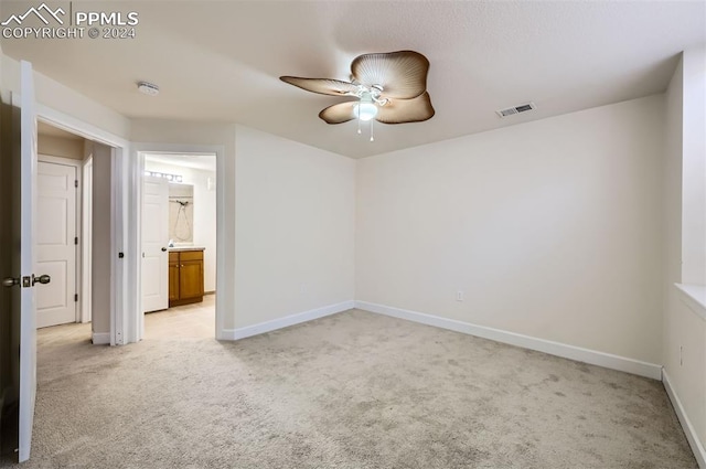 empty room with ceiling fan and light colored carpet