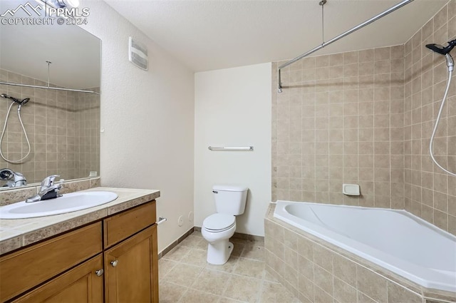 full bathroom with tile patterned flooring, tiled shower / bath combo, toilet, and vanity