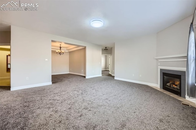 unfurnished living room with a notable chandelier and carpet floors