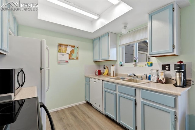 kitchen featuring blue cabinetry, dishwasher, sink, light hardwood / wood-style flooring, and range