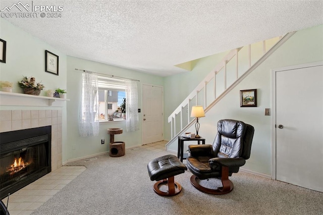 sitting room with light carpet, a textured ceiling, and a fireplace