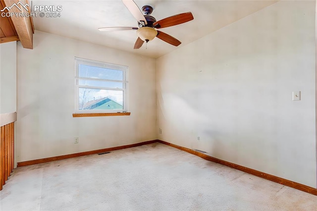 unfurnished room featuring vaulted ceiling with beams, ceiling fan, and light colored carpet