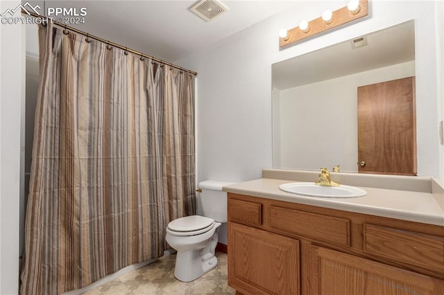 bathroom featuring vanity, toilet, and walk in shower