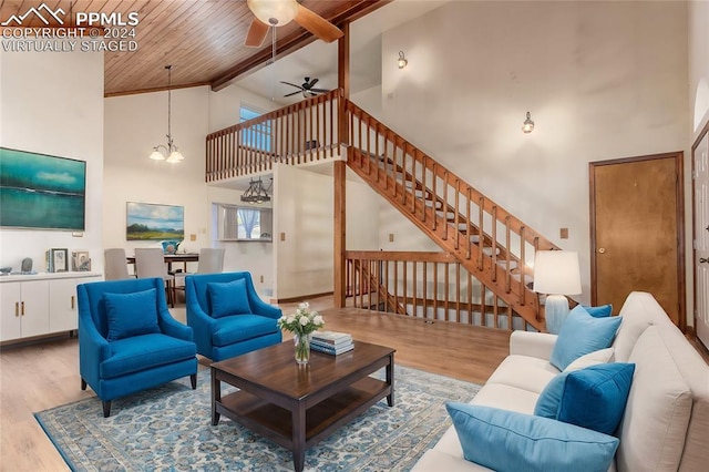 living room featuring wooden ceiling, high vaulted ceiling, ceiling fan with notable chandelier, hardwood / wood-style flooring, and beamed ceiling