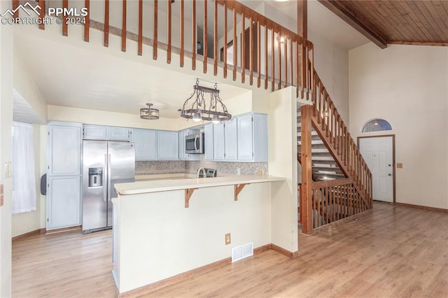 kitchen with pendant lighting, wooden ceiling, a kitchen breakfast bar, appliances with stainless steel finishes, and kitchen peninsula