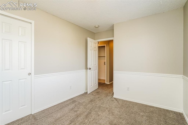 unfurnished bedroom with baseboards, carpet floors, and a textured ceiling