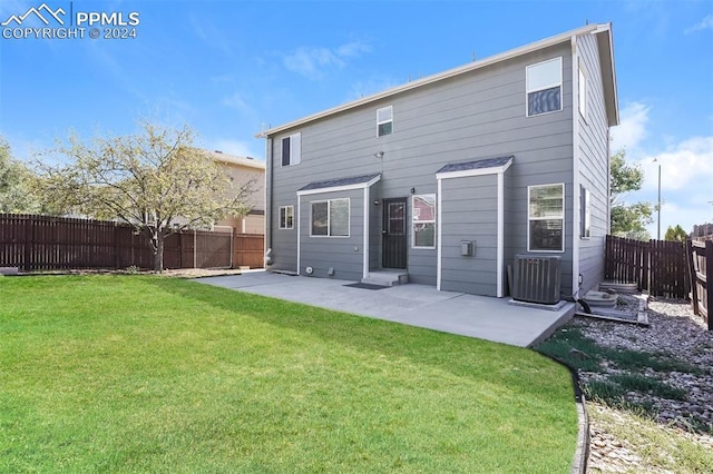 rear view of house with a lawn, central AC unit, a fenced backyard, and a patio area