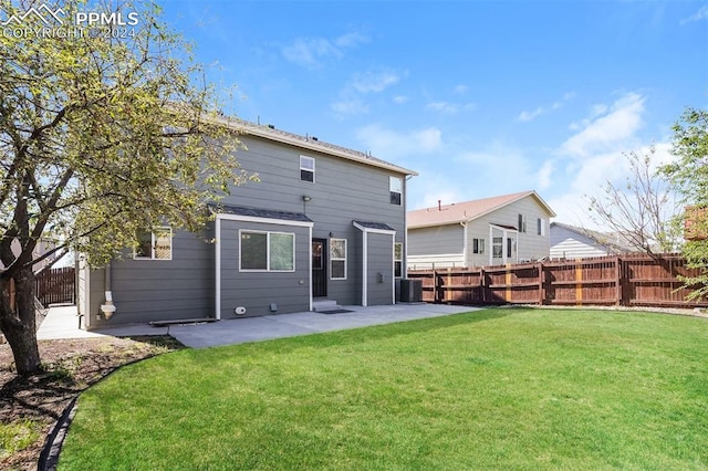 rear view of house featuring a lawn, a fenced backyard, and a patio area