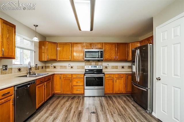 kitchen with a sink, light countertops, brown cabinetry, and stainless steel appliances