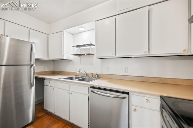 kitchen with white cabinets, appliances with stainless steel finishes, sink, and dark hardwood / wood-style floors