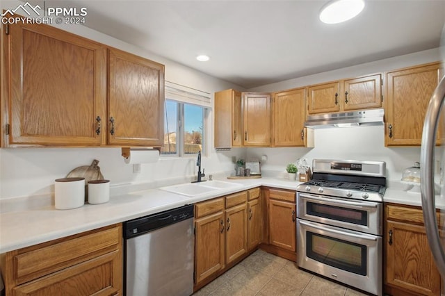 kitchen featuring light tile patterned flooring, sink, and stainless steel appliances