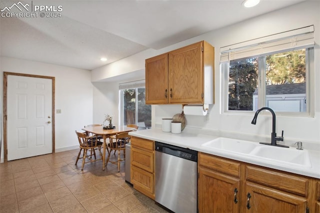 kitchen featuring light tile patterned flooring, stainless steel dishwasher, and sink