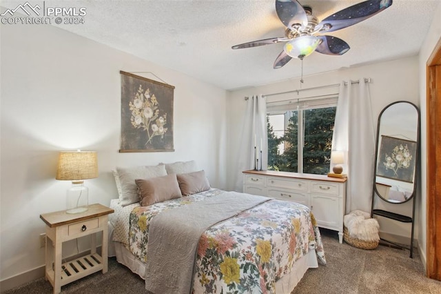 bedroom with ceiling fan, carpet, and a textured ceiling