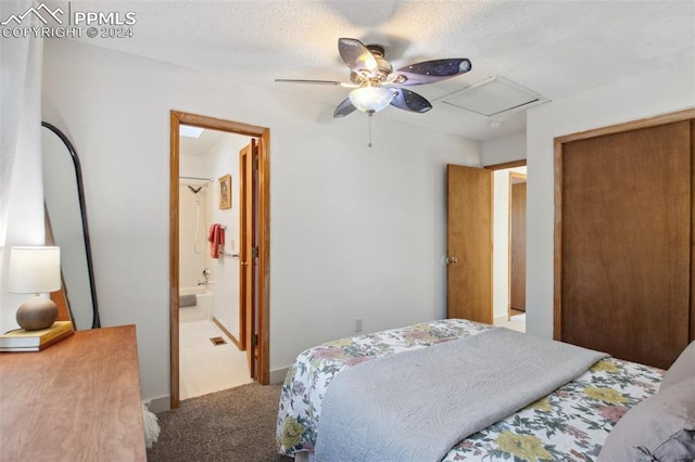 bedroom with carpet flooring, connected bathroom, ceiling fan, and a textured ceiling