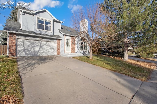 view of property with a garage and a front yard