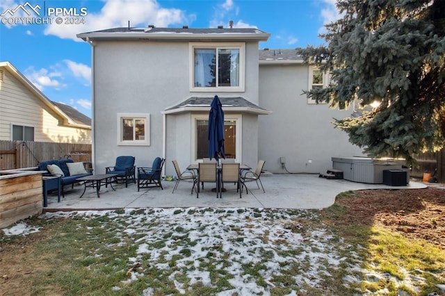 rear view of property featuring an outdoor hangout area, a patio, and a hot tub