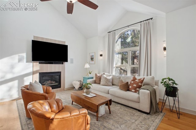 living room featuring ceiling fan, light hardwood / wood-style floors, and high vaulted ceiling