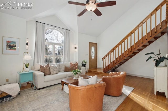 living room with light wood-type flooring, ceiling fan, and lofted ceiling