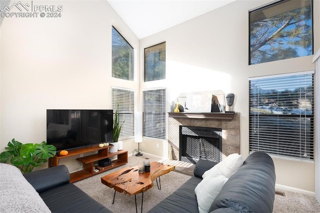 carpeted living room with a tile fireplace and lofted ceiling