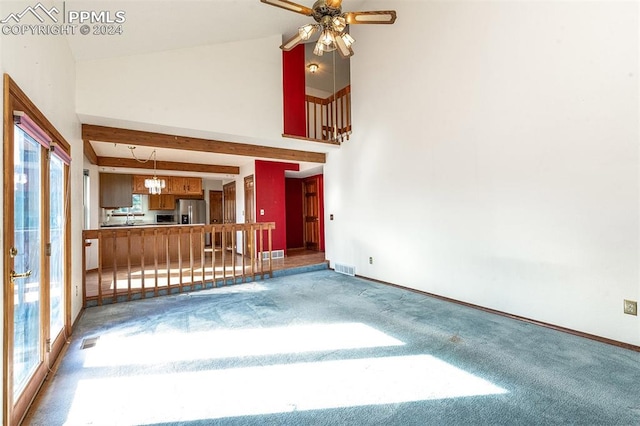 unfurnished living room featuring beamed ceiling, carpet, high vaulted ceiling, and plenty of natural light