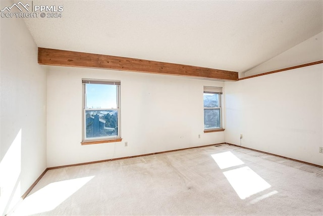 carpeted spare room featuring lofted ceiling