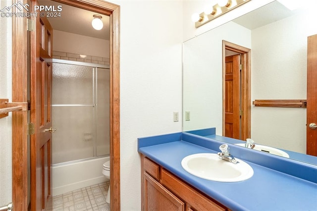 full bathroom featuring vanity, toilet, and bath / shower combo with glass door