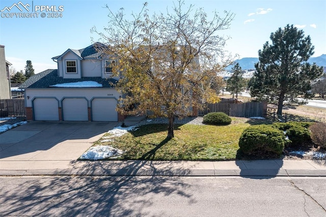 view of front of home featuring a mountain view, a garage, and a front yard