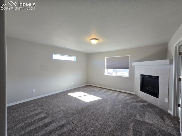 unfurnished living room with carpet flooring and a fireplace