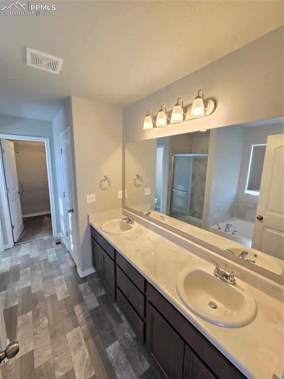 bathroom with hardwood / wood-style flooring, vanity, and independent shower and bath