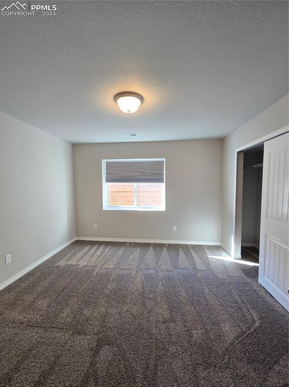 empty room featuring carpet floors and a textured ceiling