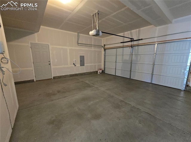 garage with a garage door opener and electric panel