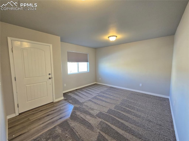 unfurnished room with dark hardwood / wood-style floors