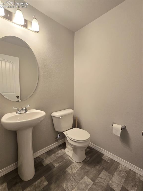 bathroom with hardwood / wood-style floors, toilet, and sink