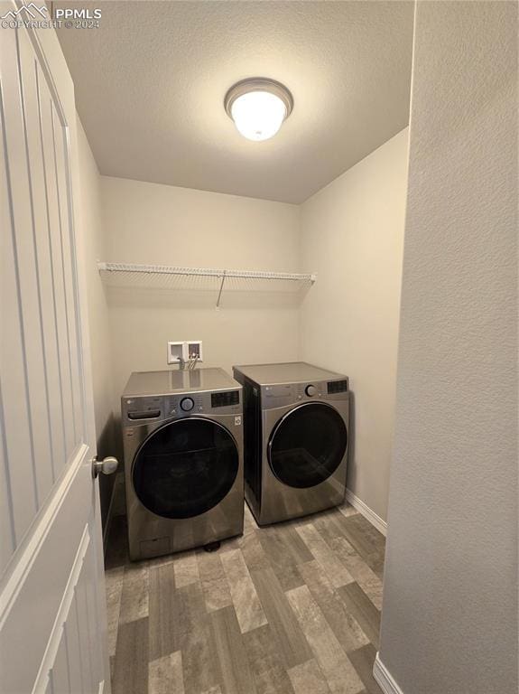 laundry room with separate washer and dryer and light hardwood / wood-style flooring