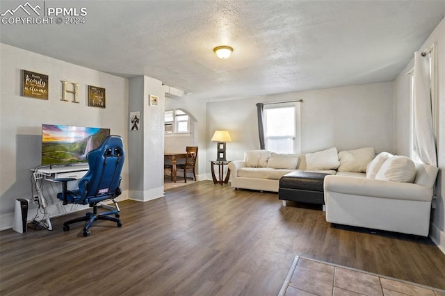 living room with a textured ceiling and dark hardwood / wood-style flooring